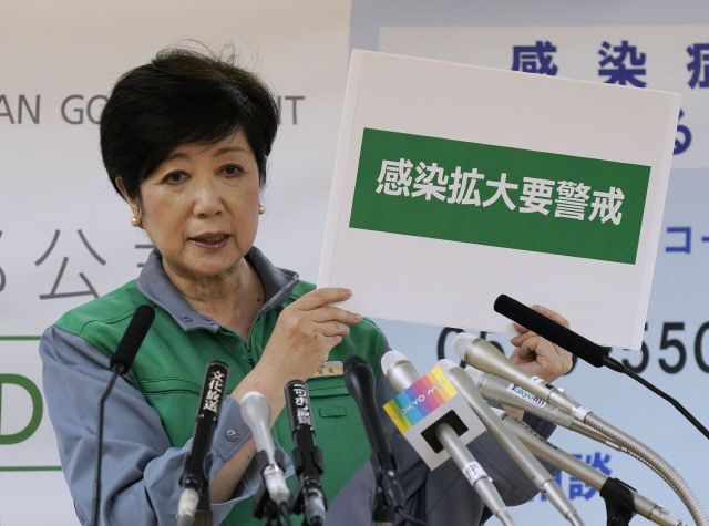 2일 고이케 유리코 일본 도쿄도 지사가 코로나19 확산과 관련해 진행된 긴급 기자회견에서 ‘감염이 확산되고 있으니 조심하세요’라고 적힌 플래카드를 들고 있다./EPA연합뉴스