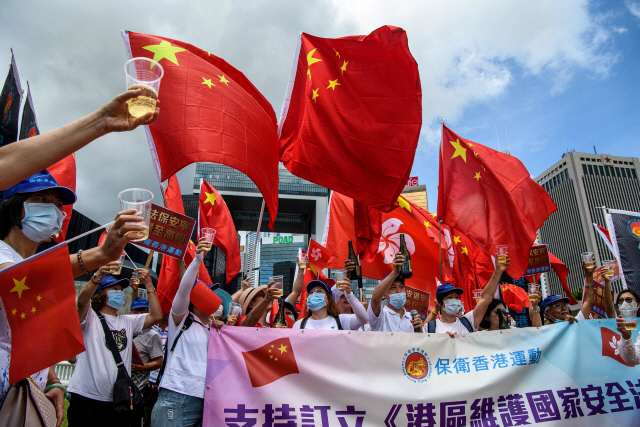 지난달 30일 ‘홍콩 보안법’의 통과를 환영하는 홍콩내 친중 시위대가 홍콩 정부청사 인근에서 중국 국기를 들고 집회를 갖고 있다. /AFP연합뉴스