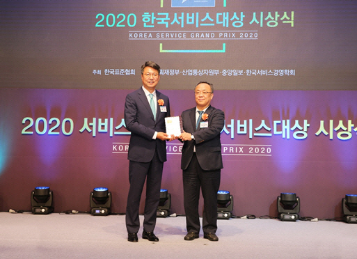 백현 롯데관광개발 대표이사(왼쪽)가 이상진 한국표준협회장(오른쪽)으로부터 2020 한국서비스대상 여행서비스 부문 종합대상을 받고 있다./사진제공=롯데관광개발