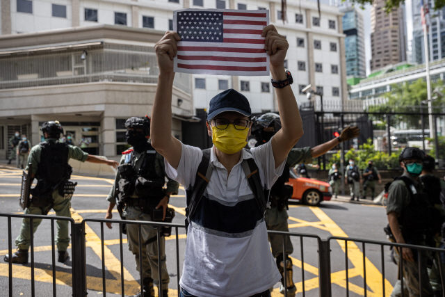 미국 독립기념일인 지난 4일 한 홍콩인이 홍콩 내 미국영사관 앞에서 미국 국기를 흔들며 국제사회의 지원을 호소하고 있다. /EPA연합뉴스