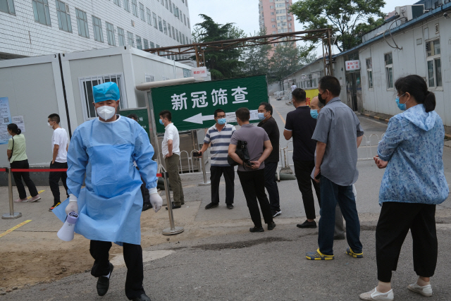 중국 수도 베이징에서 지난달 29일(현지시간) 주민들이 마스크를 쓴 채 코로나19 핵산검사를 받기 위해 병원 검사소 앞에 길게 줄지어 서 있다. /로이터연합뉴스