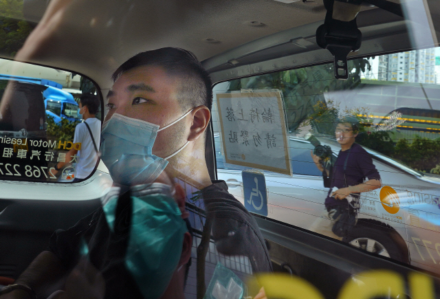 홍콩 국가보안법으로 처음 기소된 통 잉킷씨가 6일 경찰차에 실려 법원에 도착했다. 그는 홍콩보안법 반대 시위 중 ‘광복홍콩 시대혁명’이라고 적힌 깃발을 오토바이에 달고 경찰에 돌진한 혐의를 받고 있다./AP연합뉴스
