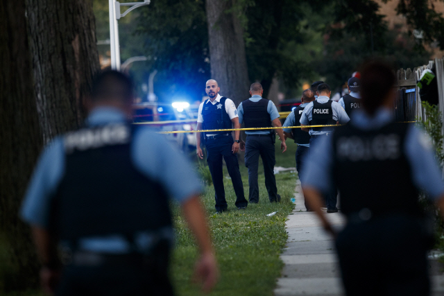 지난 5일 미국 시카고에서 한 경찰관이 7살 어린이 등이 총을 맞아 사망한 사건이 발생한 현장을 둘러보고 있다. /AP연합뉴스