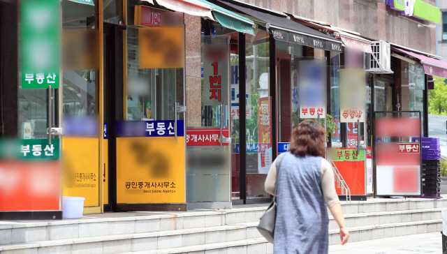 손님이 서울 송파구의 한 부동산 중개업소로 향하고 있다. 집값 상승으로 저소득층의 경우 재난지원금 지급에도 불구하고 소비가 되레 줄었을 가능성이 제기된다./연합뉴스