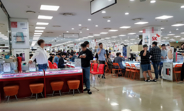 5G 스마트폰 출시 초기인 지난 해 5월 서울 신도림 테크노마트 집단상가를 방문한 소비자들이 스마트폰을 살펴보고 있다./서울경제DB