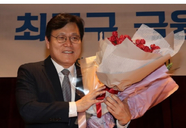 최종구 금융위원장이 지난해 9월  정부서울청사 별관에서 열린 이임식에서 꽃다발을 받고 활짝 웃고 있다. /연합뉴스