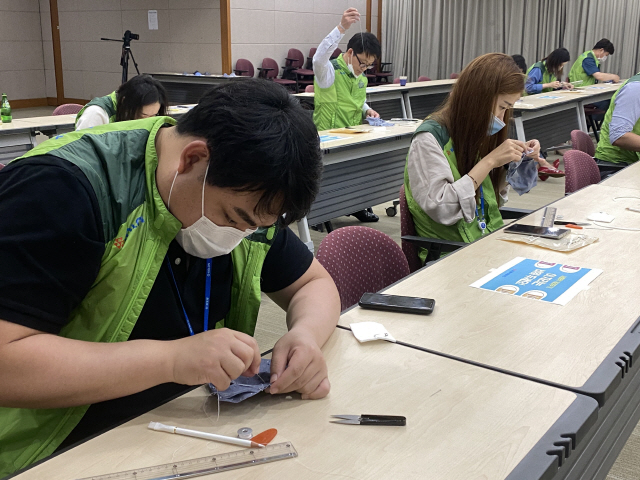 코오롱그룹 임직원들이 8일 경기 과천사옥에서 미혼모 가정 아이들에게 전해줄 면마스크를 만들고 있다. /사진제공=코오롱