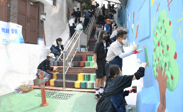 한성희(오른쪽 두 번째) 포스코건설 사장을 비롯한 임직원들이 9일 인천 배다리마을에서 벽화그리기 봉사활동을 하고 있다./사진제공=포스코건설