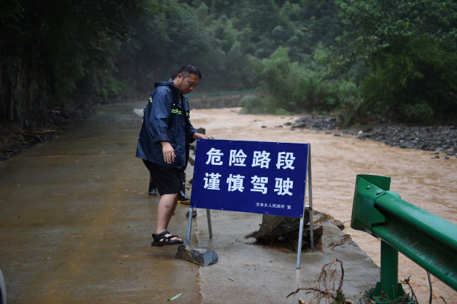 지난 8일 홍수로 도로가 파괴된 안후이성 황산시에 운전조심이라는 간판이 세워져 있다. /신화연합뉴스