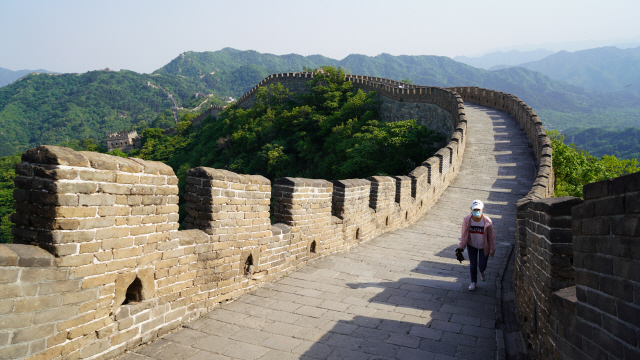 중국 베이징에 위치한 만리장성 모전욕장성 구간을 한 관광객이 오르고 있다. 사진의 왼쪽이 방위로 북쪽인데 장성은 동서로 산 능선을 따라 길게 이어져 있다.