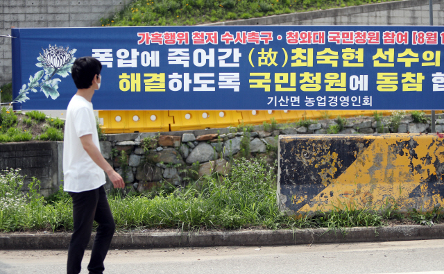 트라이애슬론 국가대표 출신 고(故) 최숙현 선수의 고향인 경북 칠곡군의 도로변에 가해 사건에 대해 철저한 수사를 촉구하는 현수막이 걸려있다. /연합뉴스