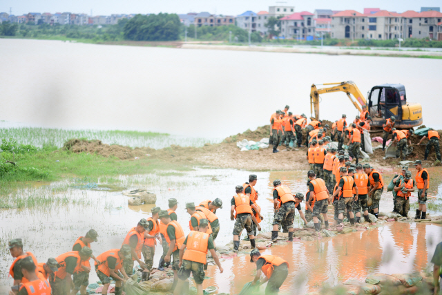 지난 12일 중국 장시성 포양호 주변에서 무장경찰들이 동원돼 둑쌓기 작업을 진행하고 있다. /신화연합뉴스