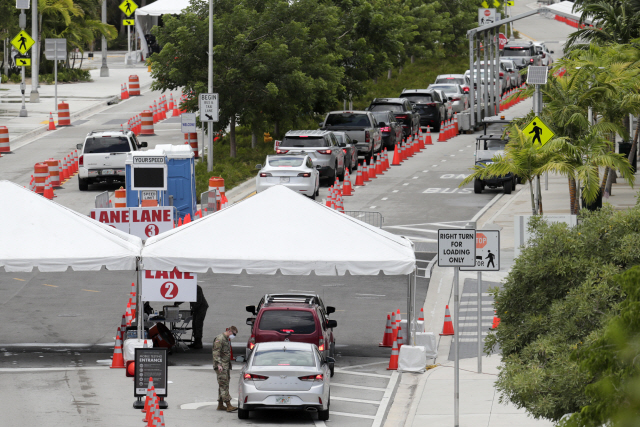 12일(현지시간) 미국 플로리다주 마이애미 비치 컨벤션센터에 설치된 진료소에 코로나19 진단 검사를 받기 위해 온 차량들이 길게 줄을 서 있다./AP연합뉴스