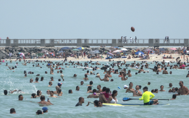 12일(현지시간) 미국 플로리다 마이애미비치를 찾은 사람들이 해수욕을 즐기고 있다. 이날 플로리다주는 역대 미국 어느 주보다도 많은 일일 신규 확진자 수를 기록했다.  /EPA연합뉴스