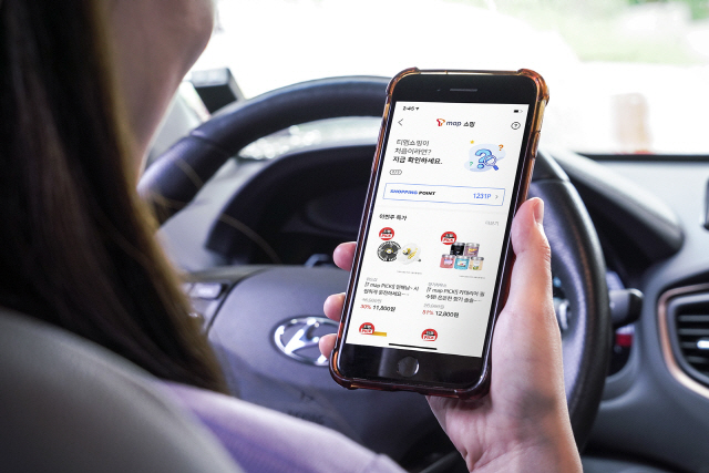 SK텔레콤 모델이 T맵 앱을 켜고 차량을 주행하고 주유할 때마다 쇼핑포인트를 적립해주는 ‘T맵 쇼핑서비스’를 14일 시연하고 있다. /사진제공=SK텔레콤