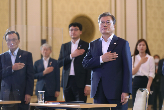 문재인 대통령이 14일 청와대 영빈관에서 열린 ‘한국판 뉴딜 국민보고대회’에서 국민의례 하고 있다./연합뉴스