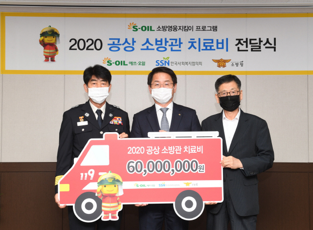 선진영(가운데) 에쓰오일 전무가 15일 마포소방서에서 부상 소방관 치료비 6,000만원을 전달한 뒤 최병일(왼쪽) 소방청 소방정책국장, 설정곤 한국사회복지협의회 사무총장과 기념촬영을 하고 있다. /사진제공=에쓰오일