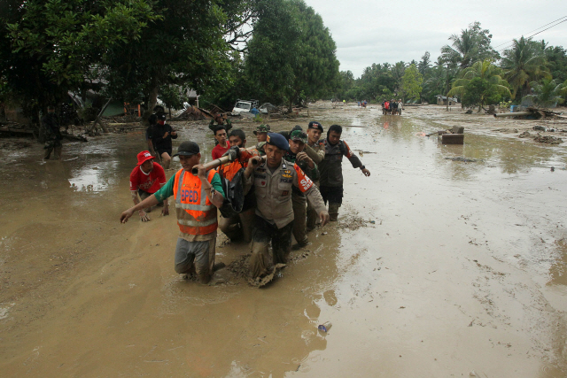 폭우가 쏟아진 인도네시아 술라웨시섬 라다 마을에 14일(현지시간) 구조대원들이 구조 작업을 벌이고 있다. /로이터연합뉴스