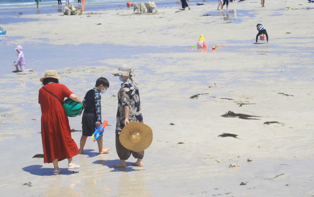 피서객들이 지난 1일 제주시 협재해수욕장을 찾아 마스크를 쓴 채 물놀이를 즐기고 있다. /제주=연합뉴스