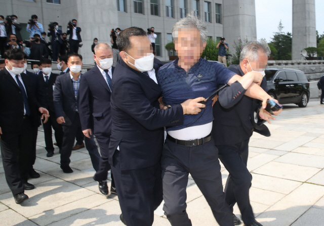 16일 오후 정모씨가 국회 본청 인근 계단 앞에서 21대 국회 개원식을 마치고 돌아가는 문재인 대통령을 향해 “북한인권 무시” 등의 구호를 외치다가 관계자에 의해  제지당하고 있다. /권욱기자