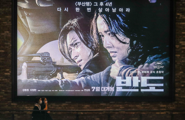 서울 시내 한 영화관에서 관객들이 영화 ‘반도’ 포스터 앞을 지나고 있다./사진=연합뉴스