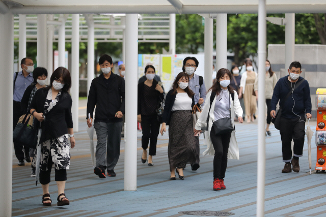 17일 일본 도쿄의 한 거리에서 시민들이 마스크를 쓴 채 지나가고 있다./사진=신화연합뉴스