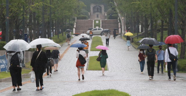 19일 오전 서울 연세대학교에서 학생들이 우산을 쓰고 길을 걷고 있다./연합뉴스