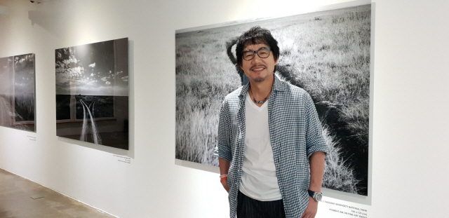 세 번째 개인전을 열고 있는 배우 겸 사진작가 박상원이 서울 강남구 송은아트스페이스에서 작품들에 대해 설명하고 있다.
