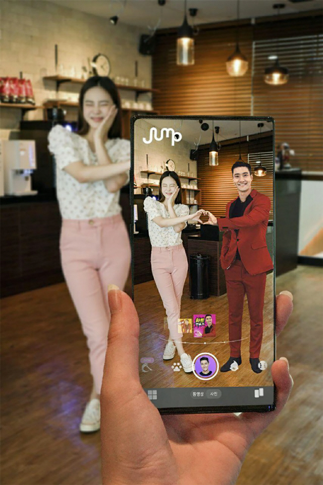 SK텔레콤 홍보모델이 점프 AR 앱에서 K팝 그룹 슈퍼주니어 멤버 최시원씨 이미지를 소환해 함께 셀카를 찍고 있다./사진제공=SKT