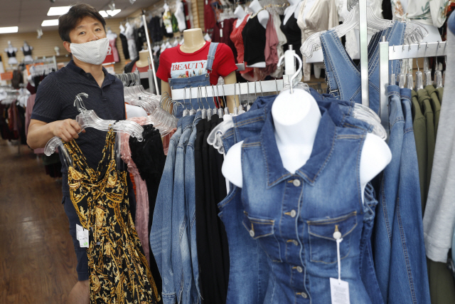 뉴욕 브룩클린의 한 옷가게에서 매장주인이 옷을 정리하고 있다. /AP연합뉴스