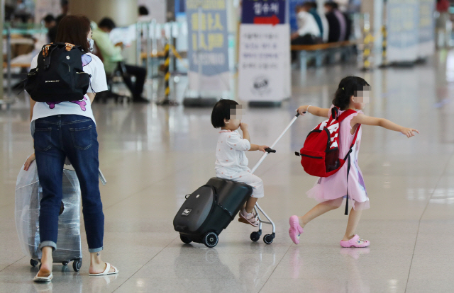 인천국제공항에서 한 어린이가 동생이 올라탄 여행용 가방을 끌고 있다./영종도=연합뉴스