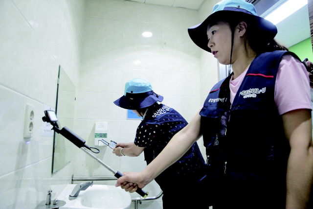 관악구 여성안심보안관이 불법촬영 카메라 탐지기를 이용해 공중화장실을 점검하고 있다./사진제공=관악구