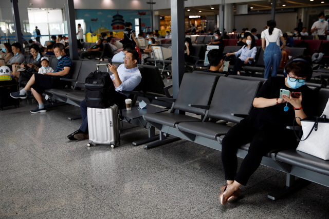 22일(현지시간) 중국 베이징 서우두국제공항에 사람들이 ‘사회적 거리두기’를 지키기 위해 멀리 떨어져 앉아있다./로이터연합뉴스