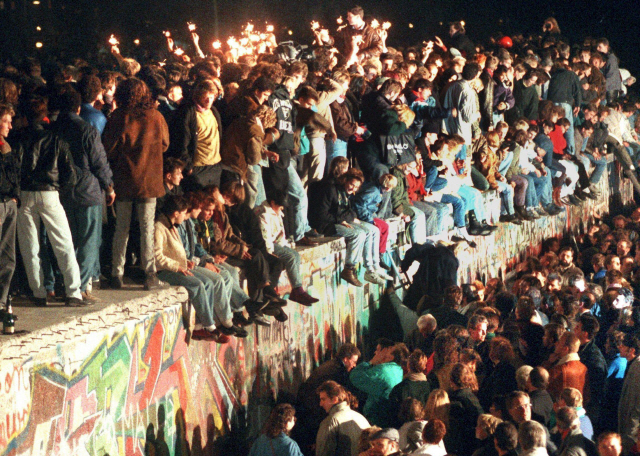 1989년 11월 독일인들이 베를린 장벽 위에 올라가 동서독 국경이 열린 것을 자축하고 있다./EPA연합뉴스