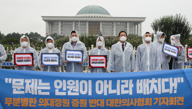 23일 국회 정문 앞에서 대한의사협회가 “문제는 인원이 아니라 배치다” 현수막을 들고 증원 반대 시위를 하고 있다. /연합뉴스