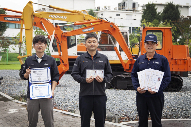 두산인프라코어가 기능장과 기술사, 국제도장감리사 등을 연이어 배출하며 기술경쟁력을 높여가고 있다. 이원호(왼쪽부터) 국제도장감리사 책임연구원, 이근재 기술사 2관왕 차장, 남병우 기능장 3관왕 기장./사진제공=두산인프라코어