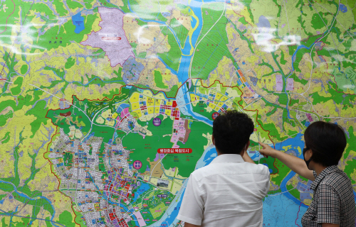 ‘22일 세종시의 한 부동산중개업소에서 아파트 매물을 문의하는 시민과 부동산 관계자가 지도를 보며 대화하고 있다./연합뉴스