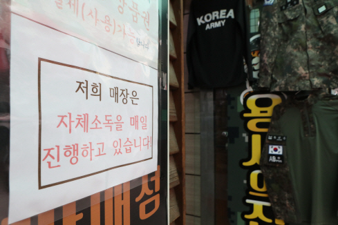 지난 22일 경기도 포천시의 한 군용 용품점에 코로나19 방역 안내문이 붙어 있다.   /포천=연합뉴스