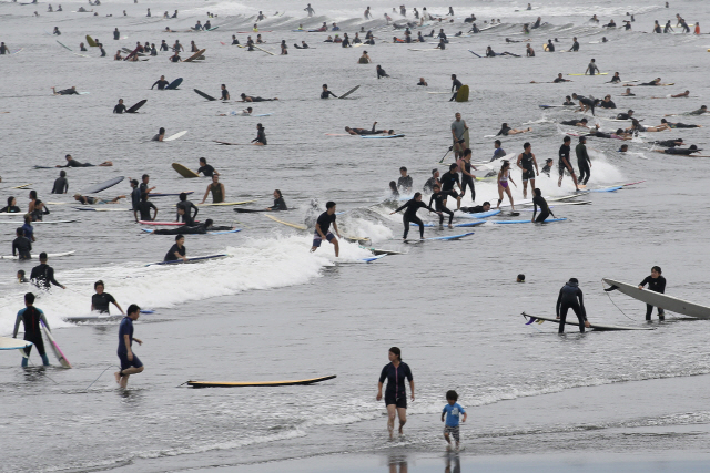 23일 일본 카나가와현의 한 해변이 서핑을 즐기는 인파로 북적이고 있다./AP연합뉴스
