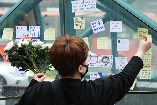 강남역 여성 살인사건 4주기를 맞은 지난 5월 17일 오후 서울 강남역 10번 출구 앞에서 시민이 추모 메시지가 적힌 포스트잇을 붙이고 있다./연합뉴스