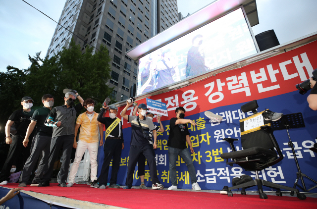 지난 25일 서울 중구 예금보험공사 앞에서 열린 ‘부동산 규제 정책 반대, 전 국민 조세 저항운동 촛불집회’에서 참가자 일부가 정부의 부동산 대책에 항의하며 신발을 던지는 퍼포먼스를 하고 있다. 이는 지난 16일 국회 개원 연설을 마치고 나오는 문재인 대통령을 비판하며 한 남성이 신발을 던진 사건을 빗댄 것으로 풀이된다. /연합뉴스