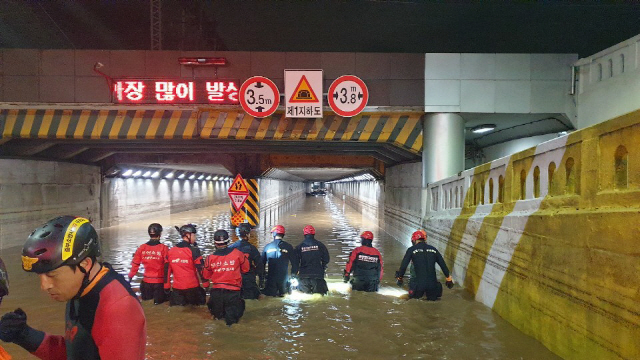 부산에 시간당 80㎜가 넘는 폭우가 쏟아진 데다 만조 시간까지 겹쳐 도심이 물바다로 변한 가운데 갑자기 불어난 물로 침수된 지하차도에 갇혔던 3명이 숨졌다. /연합뉴스