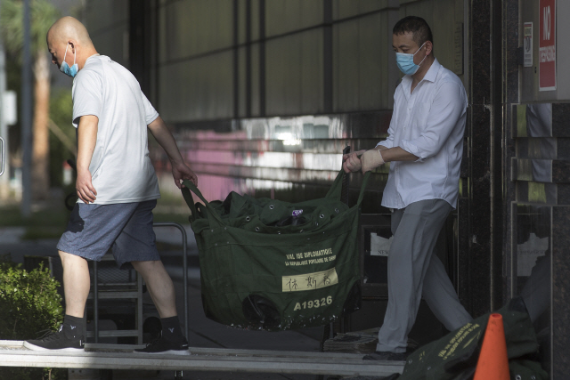24일(현지시간) 미국 텍사스주 휴스턴에 있는 중국 총영사관에서 직원들이 외교행낭을 건물 밖으로 옮기고 있다./AFP·AP연합뉴스