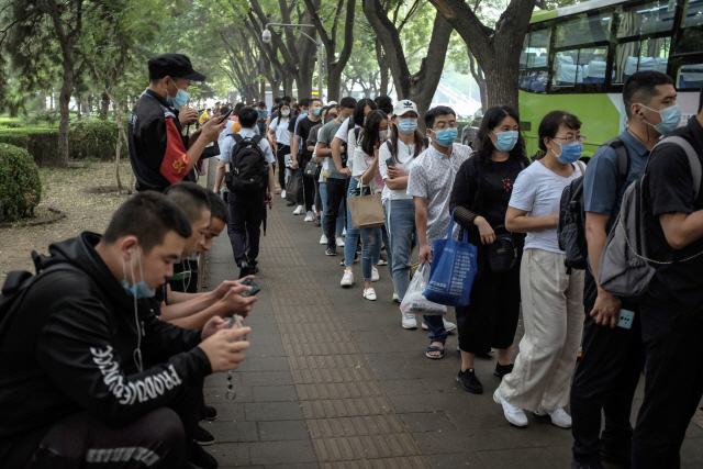 지난 27일 중국 베이징 중심가에서 시민들이 마스크를 한 채 버스를 기다리고 있다. /EPA연합뉴스