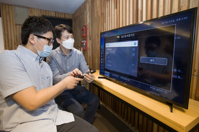 삼성전자 상품전략팀 직원(오른쪽)이 서울 관악구에 위치한 실로암 시각장애인 복지관에서 한 시각장애인에게 삼성전자 스마트TV의 접근성 기능에 대해 설명하고 있다./사진제공=삼성전자