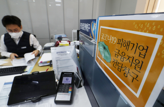 서울 중구 신한은행 남대문점에서 한 직원이 코로나19로 피해를 입은 한 소상공인의 대출 신청을 받고 있다. /연합뉴스