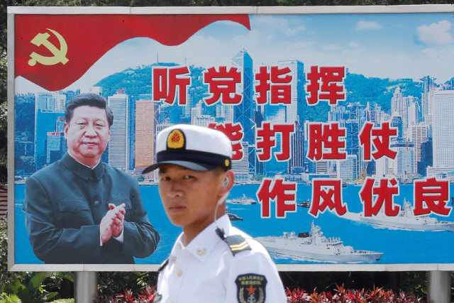 지난해 6월 중국 인민해방군 해군 장병이 홍콩의 한 해군기지에서 시진핑의 모습이 그려진 홍보판 앞에 서있다. 시진핑의 일반적인 호칭은 중국 공산당 중앙위원회 ‘총서기’지만 군에서는 ‘시 주석’으로 부른다. 그는 중공 중앙군사위원회 주석 직위도 보유하고 있기 때문이다. /로이터연합뉴스