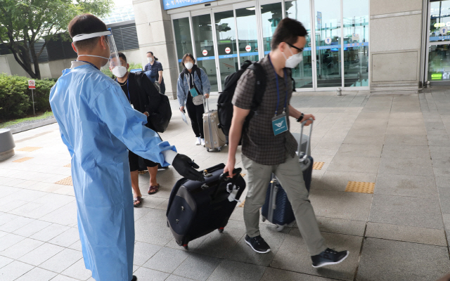 지난 27일 오후 인천국제공항에서 관계자들이 외국인 입국자들을 안내하고 있다. /영종도=연합뉴스