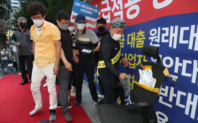 25일 오후 서울 중구 예금보험공사 앞에서 열린 ‘소급적용 남발하는 부동산 규제 정책 반대, 전국민 조세 저항운동 촛불집회’ 참가자들이 문재인 대통령 글자가 적힌 의자에 신발을 던지는 퍼포먼스를 하고 있다. /연합뉴스