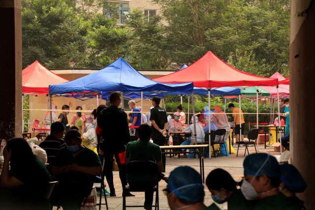 중국 의료진이 28일(현지시간) 베이징 창핑구(區)의 주거지역에 마련된 임시 검사소에서 코로나19 핵산 검사를 위해 주민들의 검체를 채취하고 있다. /로이터연합뉴스